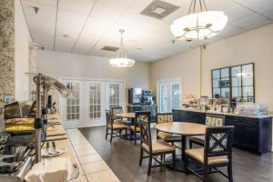 a restaurant with tables and chairs in a room at Clarion Inn & Suites Central Clearwater Beach in Clearwater