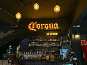 a bar with a liquor sign hanging above a counter at TUKTUK Home in Samphanthawong +10 photos
