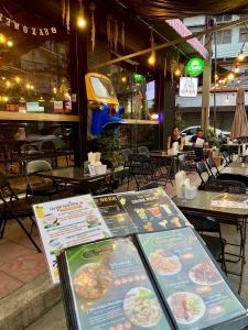 a restaurant with tables and chairs and signs in front of it at TUKTUK Home in Samphanthawong