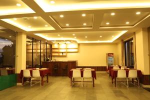 a restaurant with tables and chairs in a room at Royal Jungle Villas in Sauraha