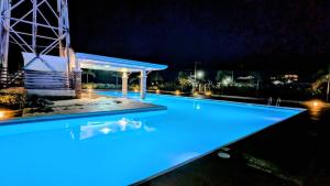 a swimming pool lit up at night at Cityloft Bungalow in Dauis