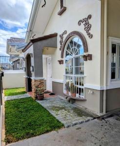 a white house with a door and a yard at Cityloft Bungalow in Dauis
