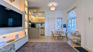a kitchen and dining room with a table and a television at Cityloft Bungalow in Dauis