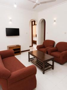 a living room with two couches and a coffee table at Prestige Leisure Hotel in Mtwapa