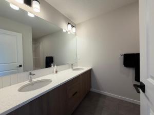 a bathroom with a sink and a large mirror at Beautiful New House in Alpine Park, Calgary in Calgary +14 photos