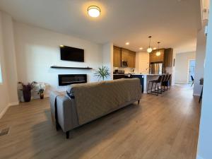 a living room with a couch and a kitchen at Beautiful New House in Alpine Park, Calgary in Calgary