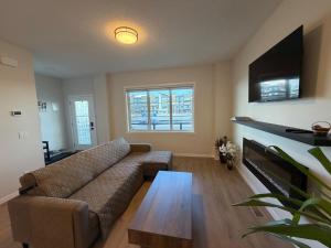 a living room with a couch and a coffee table at Beautiful New House in Alpine Park, Calgary in Calgary