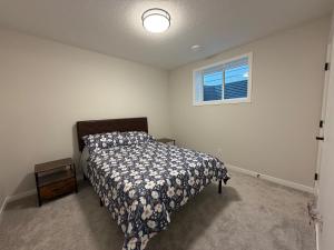 a bedroom with a bed and a window at Beautiful New House in Alpine Park, Calgary in Calgary
