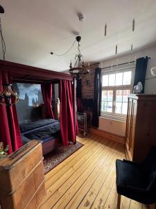 a bedroom with a bed with red curtains at Gutenacht Bahnhof in Weimar