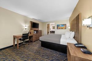 a hotel room with a large bed and a desk at Quality Inn & Suites Hesperia-Victorville in Hesperia