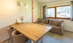 a living room with a wooden table and a couch at hus9 in Mittelberg