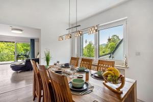 a dining room with a wooden table with chairs and a dining room at Ferienwohnung Sauerland an der Ruhr in Olsberg +37 photos