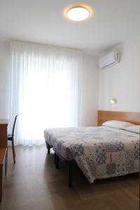 ein Schlafzimmer mit einem Bett und einem großen Fenster in der Unterkunft Hotel Soave in Cervia