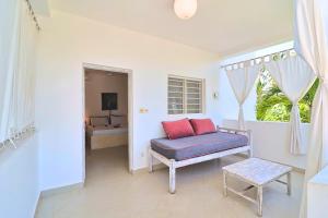 a living room with a bench and a window at Ascot Watamu Resort in Watamu
