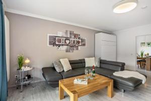 a living room with a black couch and a table at Ferienwohnung Sauerland an der Ruhr in Olsberg