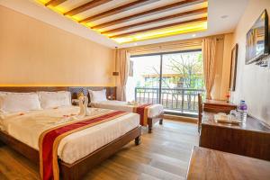 a hotel room with two beds and a balcony at Royal Jungle Villas in Sauraha +187 photos