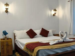 a bedroom with a bed with two swans on it at Shampagne Villa in Cochin