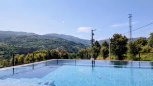 a swimming pool with mountains in the background at Casa Calmavista in Paços de Gaiolo