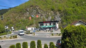 a street with cars driving on a road with a building at Kamel Rooms & Apartments in Bijelo Polje