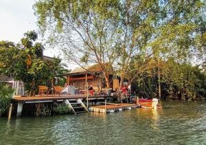 ein Haus auf einem Steg an einem Gewässer in der Unterkunft Amphawa Hideaway in Amphawa