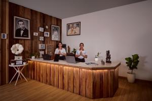 three women sitting at a reception desk with laptops at One Beach Resort by EHM in Koh Rong Sanloem