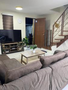 a living room with a couch and a tv at As Thetic Transient in San Pablo
