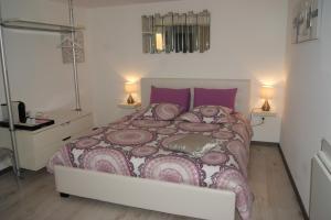 a bedroom with a large bed with purple pillows at B&B Villa Castelnau Montpellier in Castelnau-le-Lez