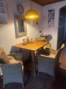 a dining room table with chairs and a yellow light at Herzenslicht in Ingenried +15 photos