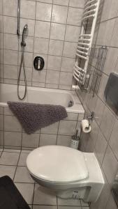 a bathroom with a toilet and a bath tub at Herzenslicht in Ingenried
