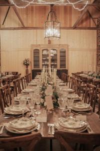 a long table in a barn with chairs and a chandelier at Domaine du tertre ychot in Dol-de-Bretagne