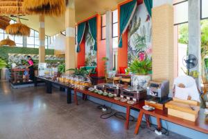 a store with a long table with food on it at Tolani Resort Koh Samui in Lamai