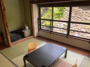 a room with a table and a chair and a window at Takaragawa Onsen Ousenkaku in Minakami