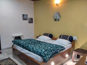 a bedroom with a bed with a green comforter at The Explorer's Den in Munsyari