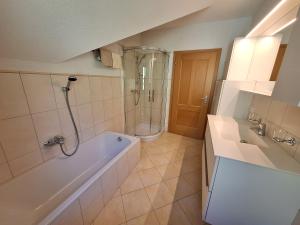 a bathroom with a tub and a shower and a sink at Privatzimmer am Weinbrunnen in Vorchdorf