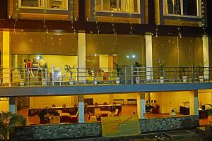 a large building with people sitting on a balcony at Doon Sanskaram Hotel in Chūharpur