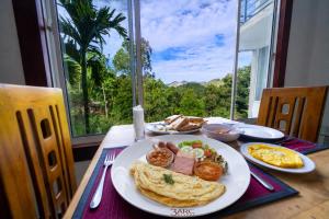 a plate of breakfast food on a table with a view at 3 Arch Resort Ella in Ella