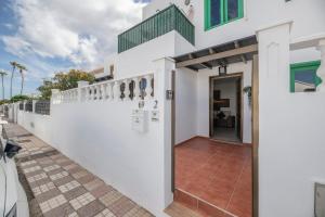 a white house with a pathway leading to the front door at Casa Emma in Playa Honda