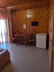 a room with a table and chairs and a television at Бирюза in Karolino-Buhaz