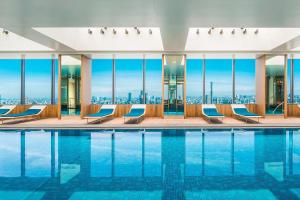a pool with chairs and a view of the city at The Prince Gallery Tokyo Kioicho, a Luxury Collection Hotel in Tokyo