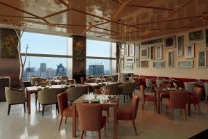 a restaurant with tables and chairs and large windows at The Prince Gallery Tokyo Kioicho, a Luxury Collection Hotel in Tokyo