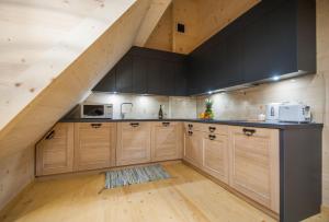 an attic kitchen with wooden cabinets and a staircase at Apartament Tatrzański in Zakopane