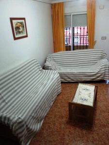 Habitación con 2 camas, mesa y ventana en La Herrada, en Los Montesinos