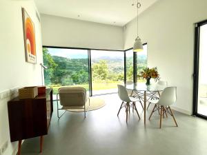 a dining room with a table and chairs and a large window at Casa Calmavista in Paços de Gaiolo