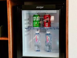 a refrigerator filled with bottles and cans of milk at Liaoxin Valley Forest Hotel in Jiezi Ancient Town