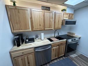 a kitchen with wooden cabinets and a sink and a stove at Anchorage Fireoved Experience in Anchorage