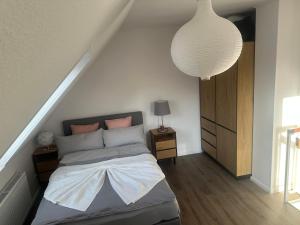 a bedroom with a bed and a pendant light at Quendel & Äpfel Ferienhaus in Neu Wulmstorf