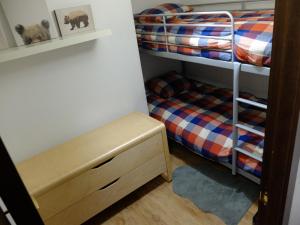 a room with two bunk beds and a bench in it at Apartamento Valdenieve VUTE-15-041 in Valdelinares