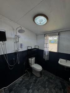a bathroom with a shower and a toilet and a sink at ภูมิคิมมินทร์ รีสอร์ท & สปา in Ban Chai Na