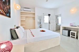 a white bedroom with a large bed with flowers on it at Ascot Watamu Resort in Watamu