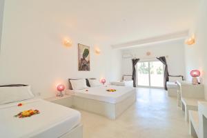 a large white room with two beds and chairs at Ascot Watamu Resort in Watamu +60 photos